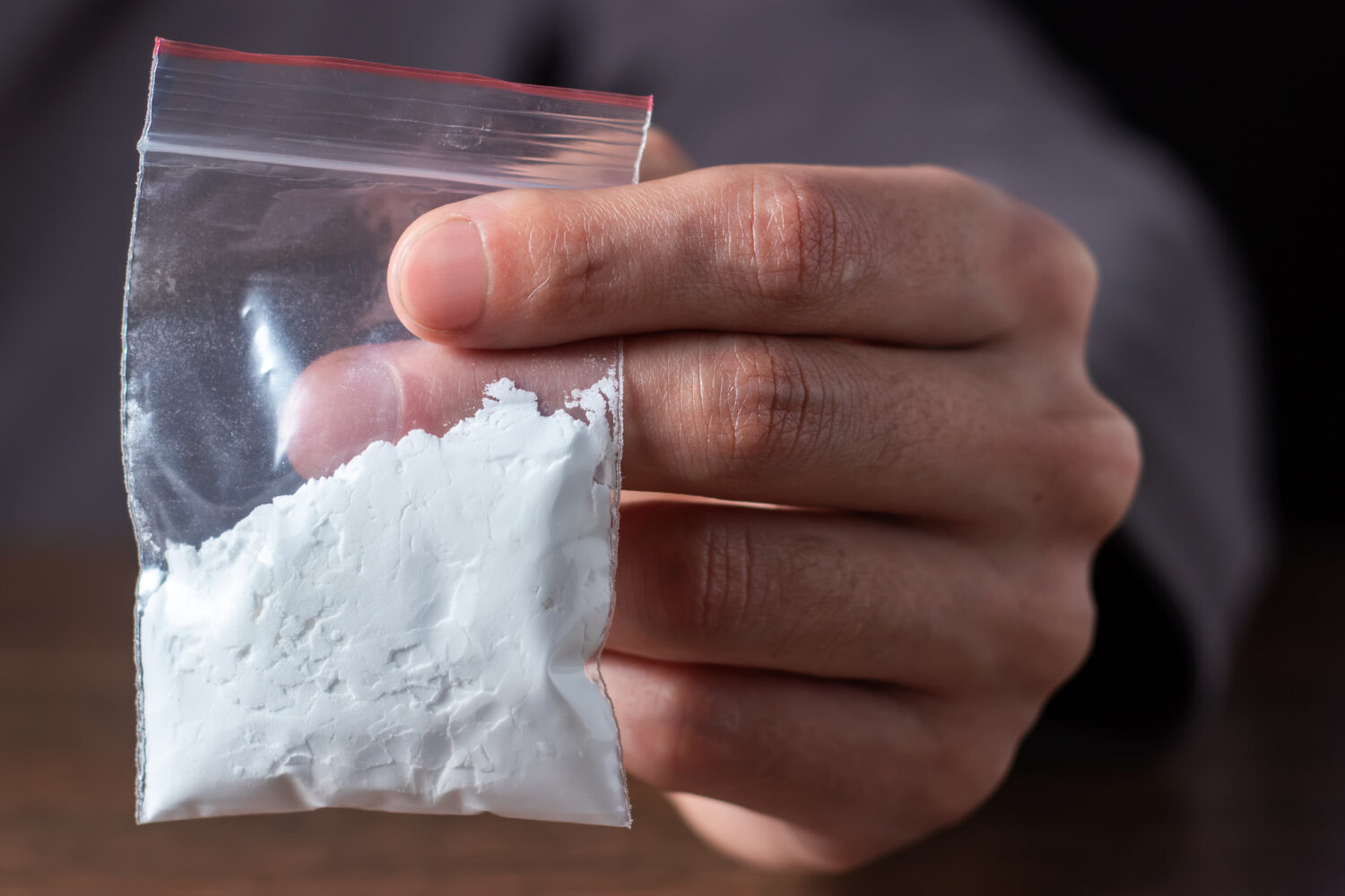 Man holding bag of cocaine mixed with fentanyl