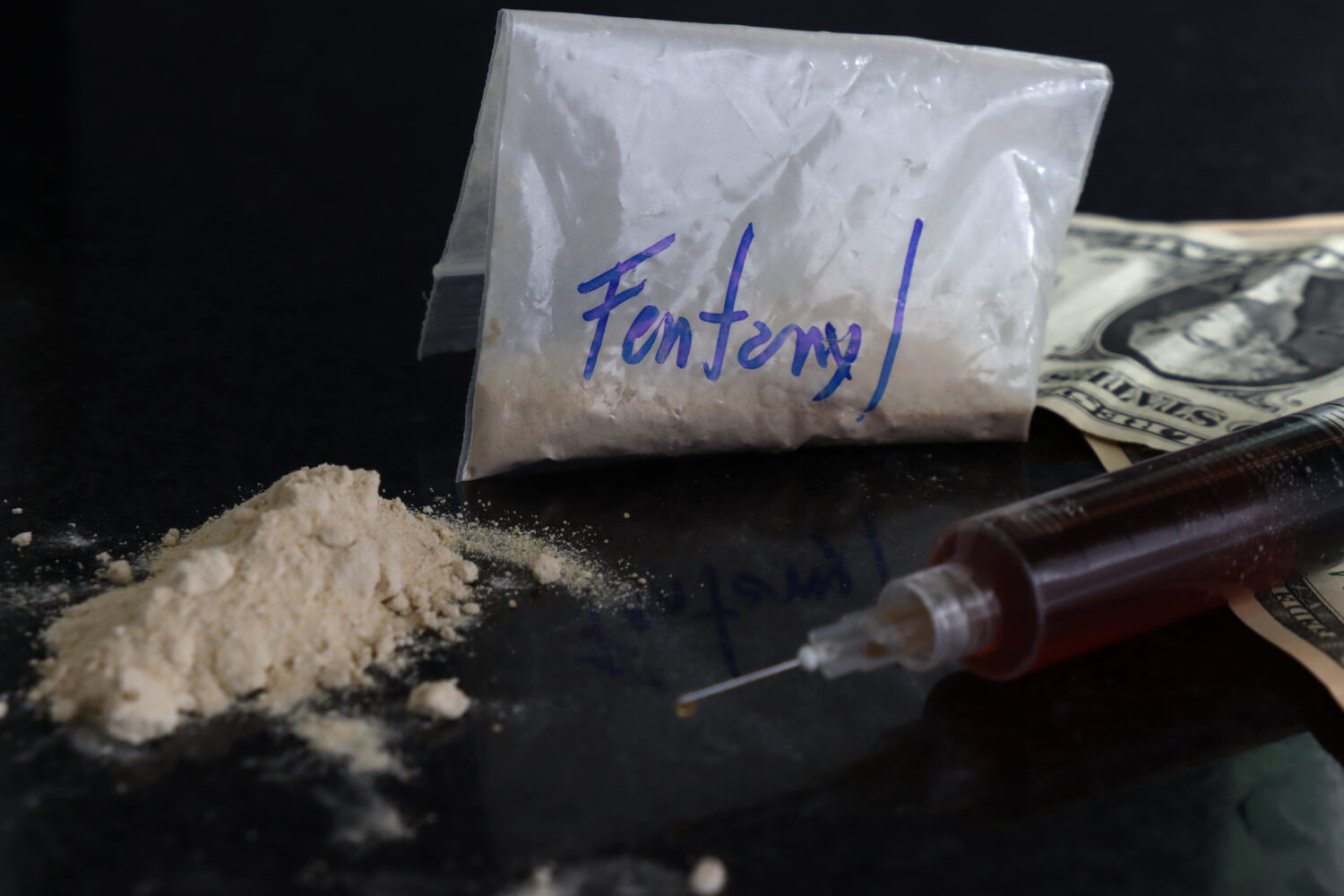 fentanyl baggie with powder and a syringe nearby overdose prevention